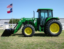 John Deere Tractor With Front End Loader Front of American and Texas Flags